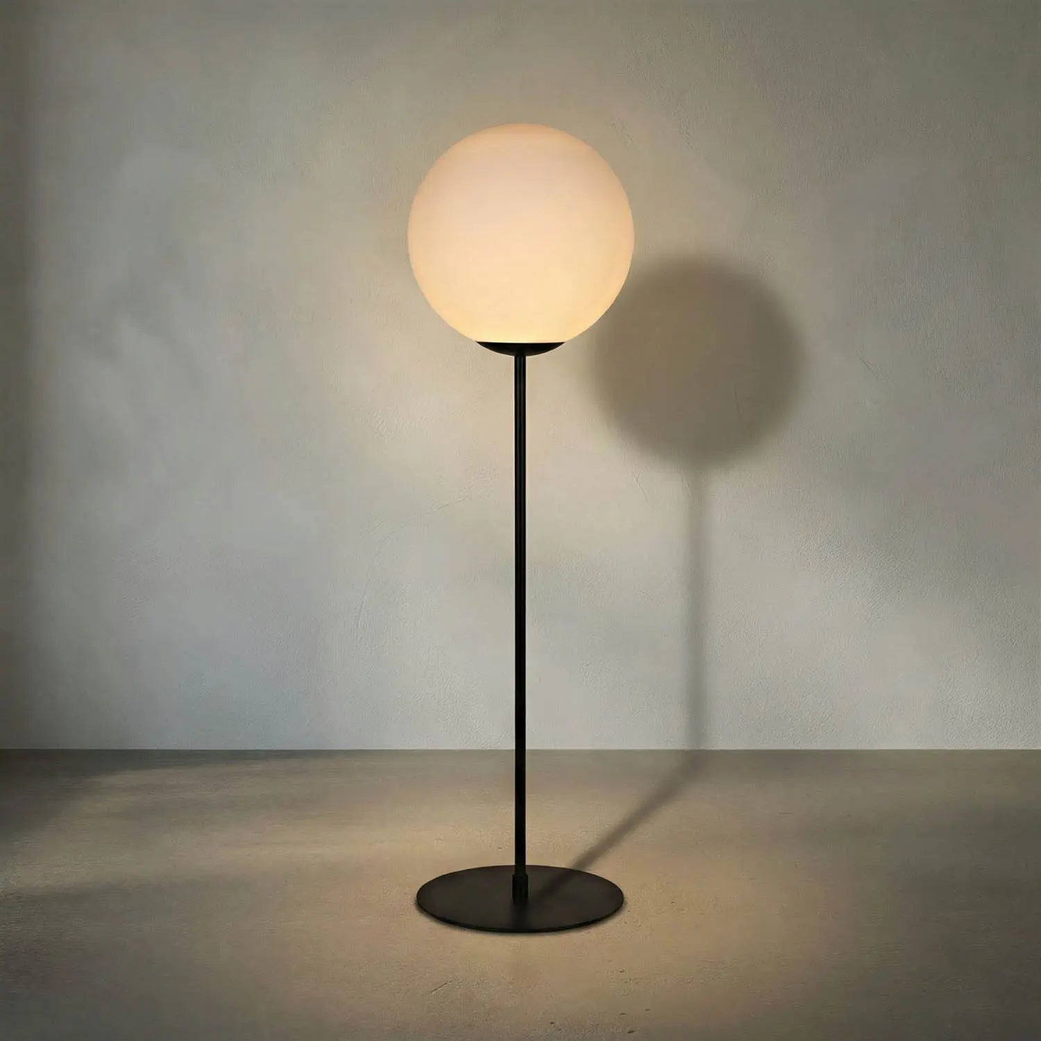Floor lamp with a round glass shade on a dark background