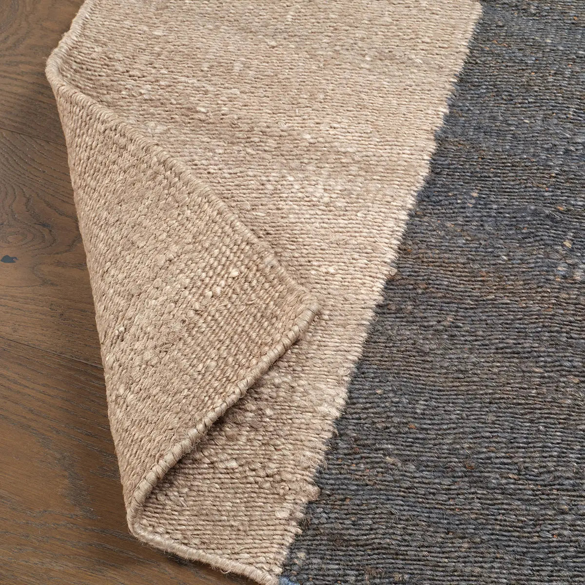 Close-up of a textured beige rug on a wooden floor