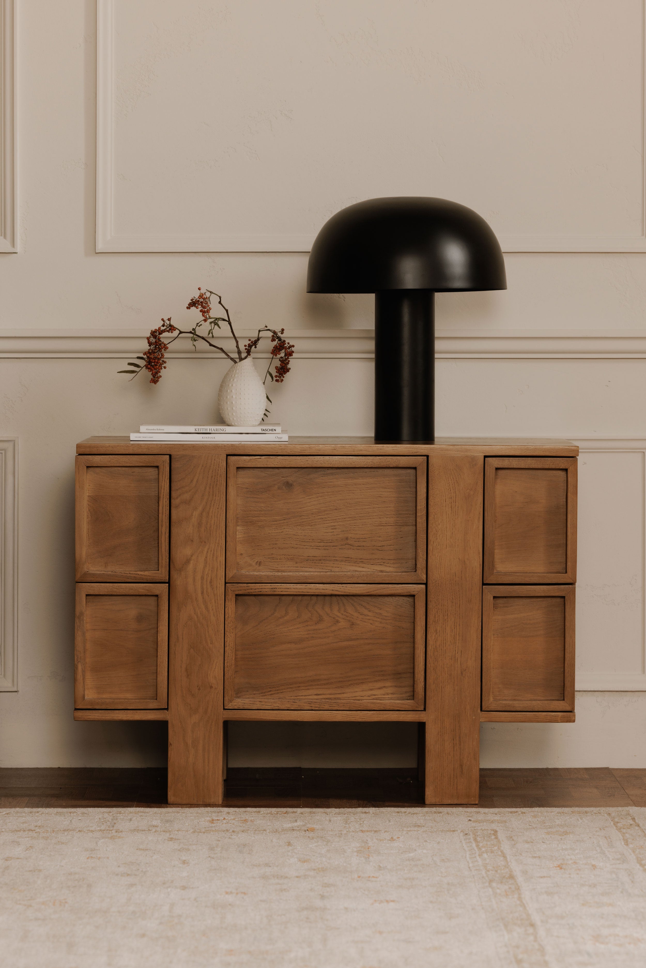Wooden sideboard with multiple doors with a modern lamp and vase