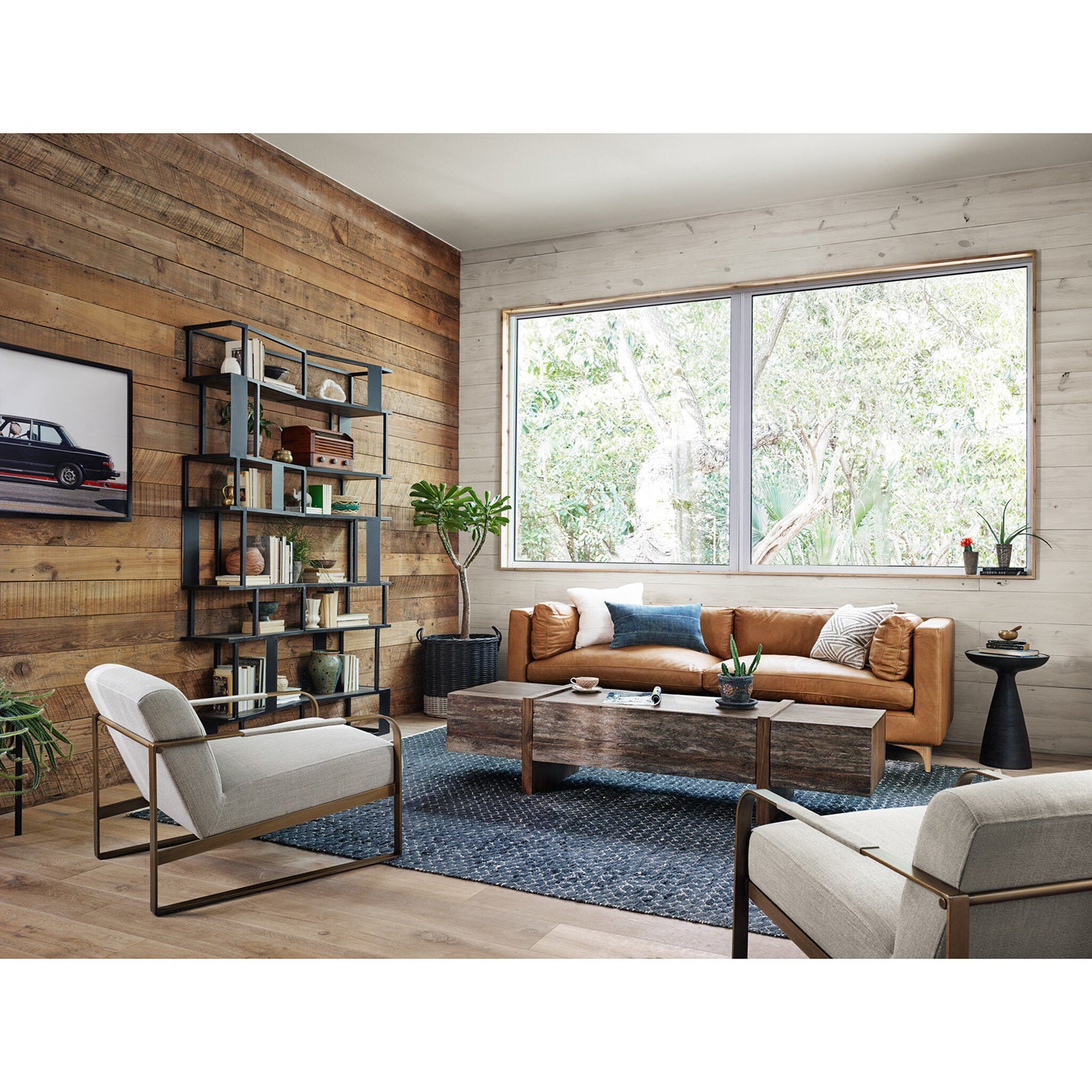 Modern living room with wooden walls, a large window, and stylish furniture.