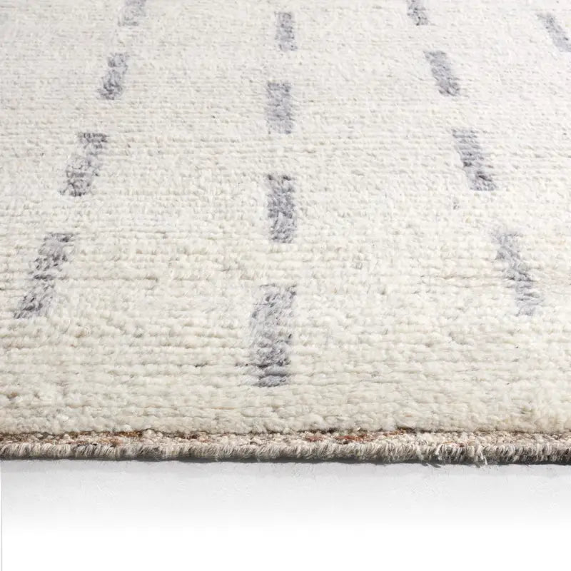 Close-up of a beige textured rug with a geometric pattern on a white background