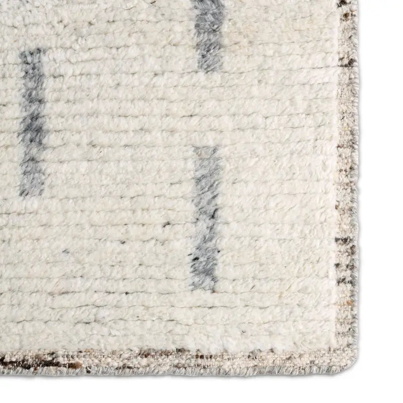 Close-up of a textured rug with a neutral color palette on a white background