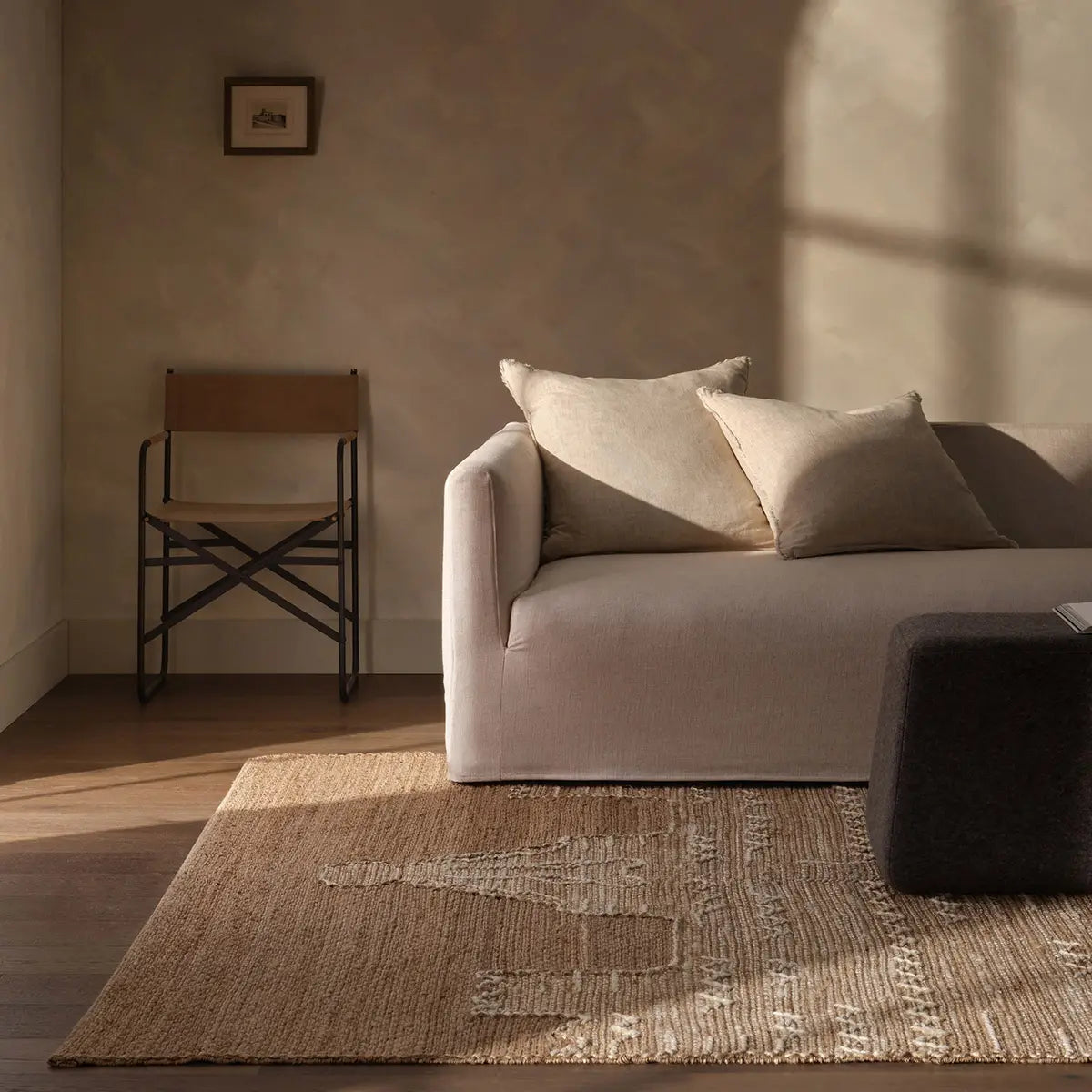 Living room with a beige sofa, chair, and textured rug.