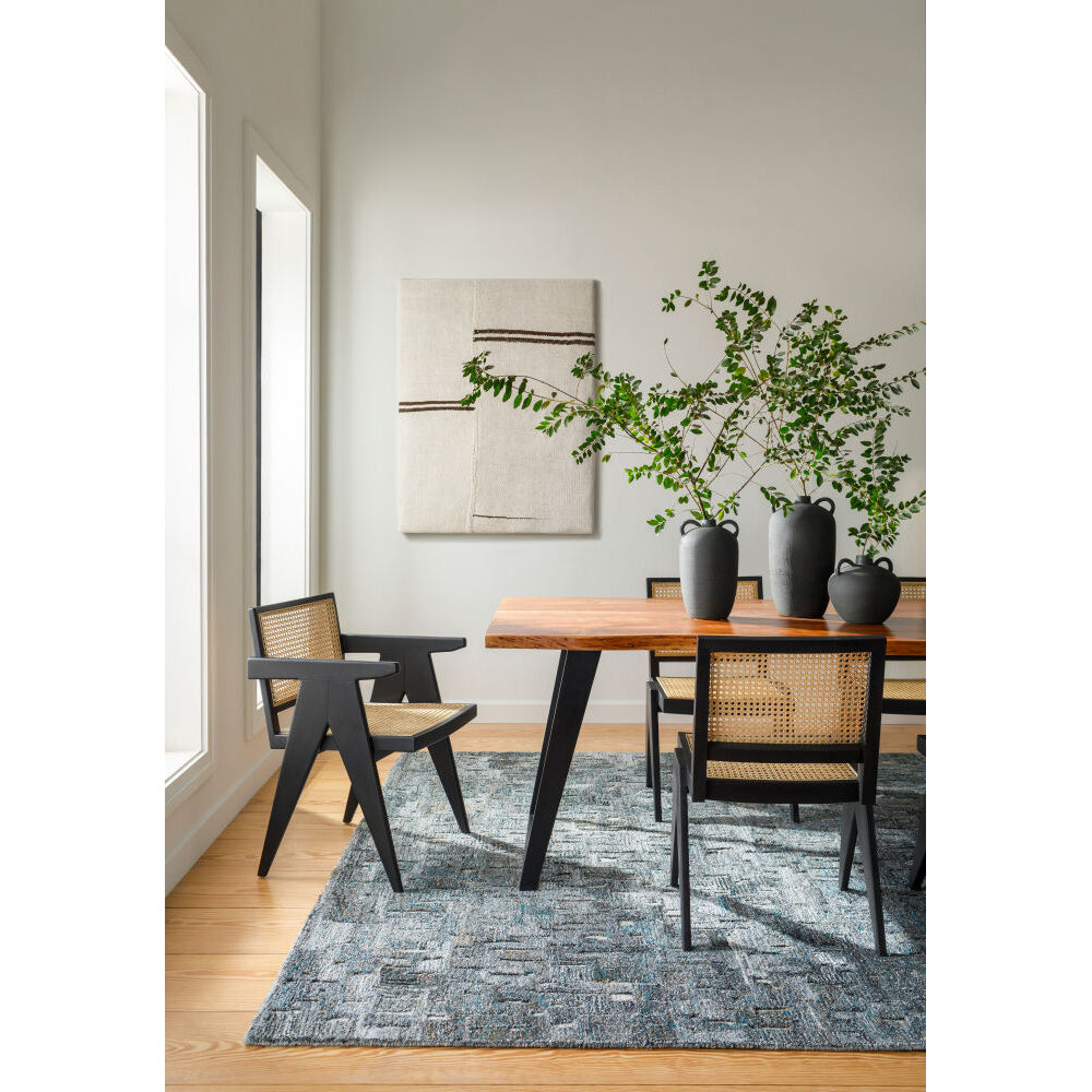 Dining room with wooden table, chairs, and decorative plants.