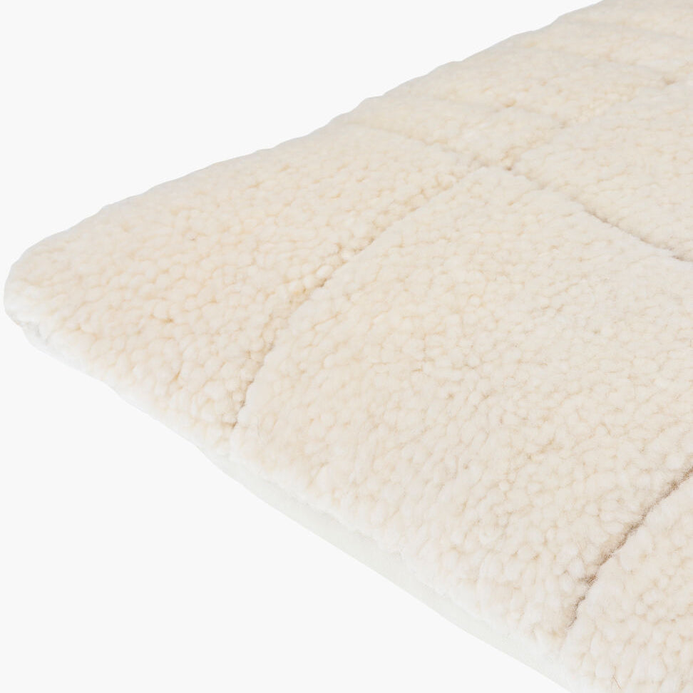 Close-up of a textured beige pillow on a white background