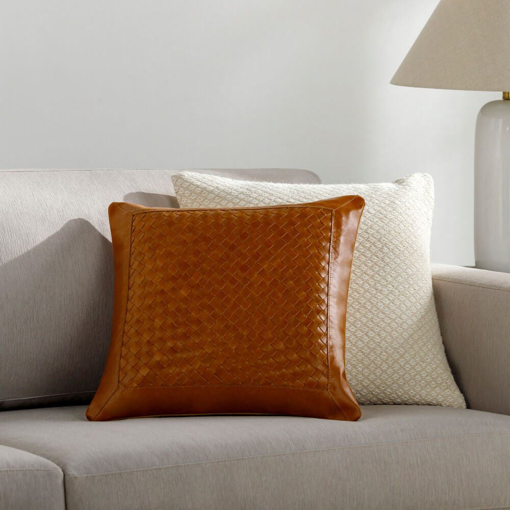 Brown textured pillow on a gray sofa with a neutral background