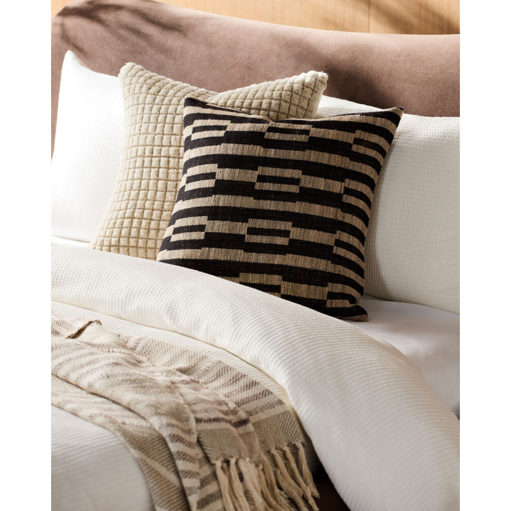 Decorative pillows on a sofa with a blanket