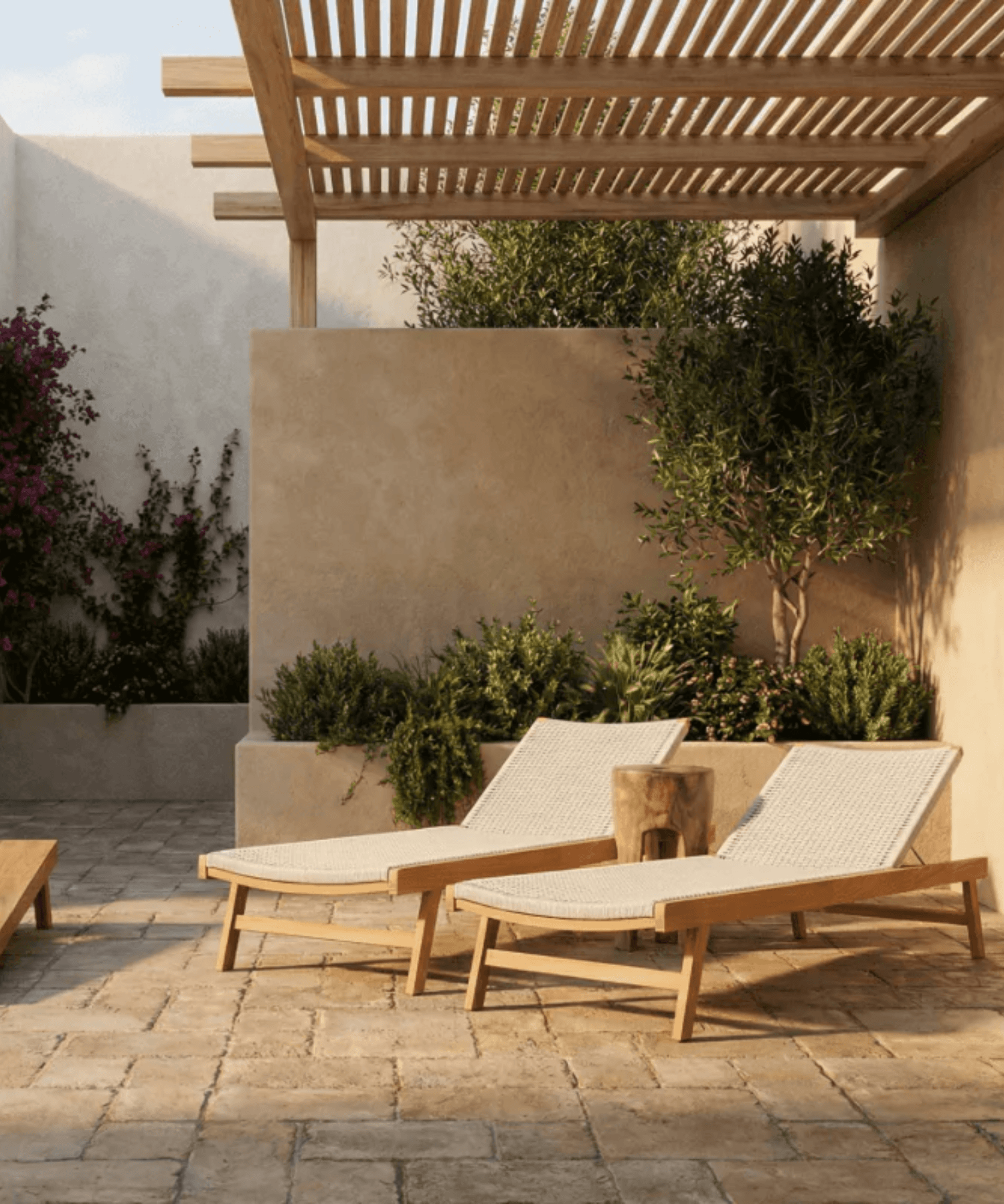Two wooden lounge chairs with white cushions on a patio under a pergola.