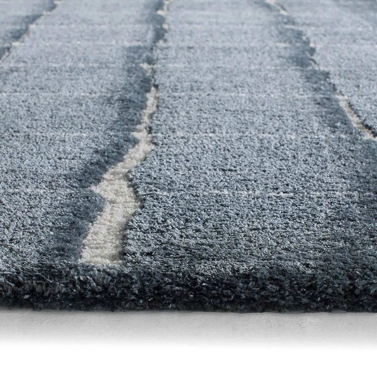 Close-up of a textured gray rug with a white line running through it.