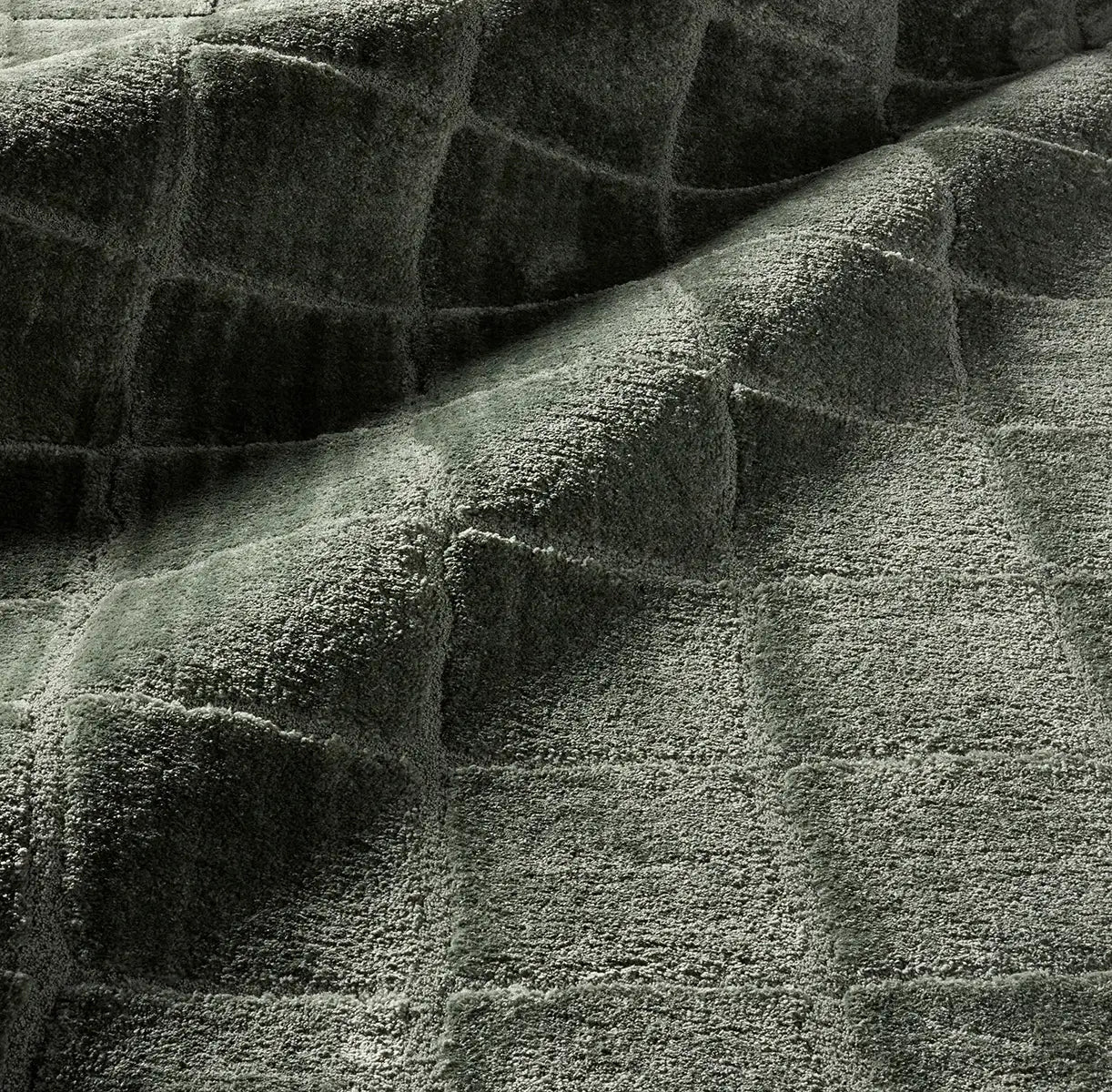 Close-up of textured green fabric with a checkered pattern