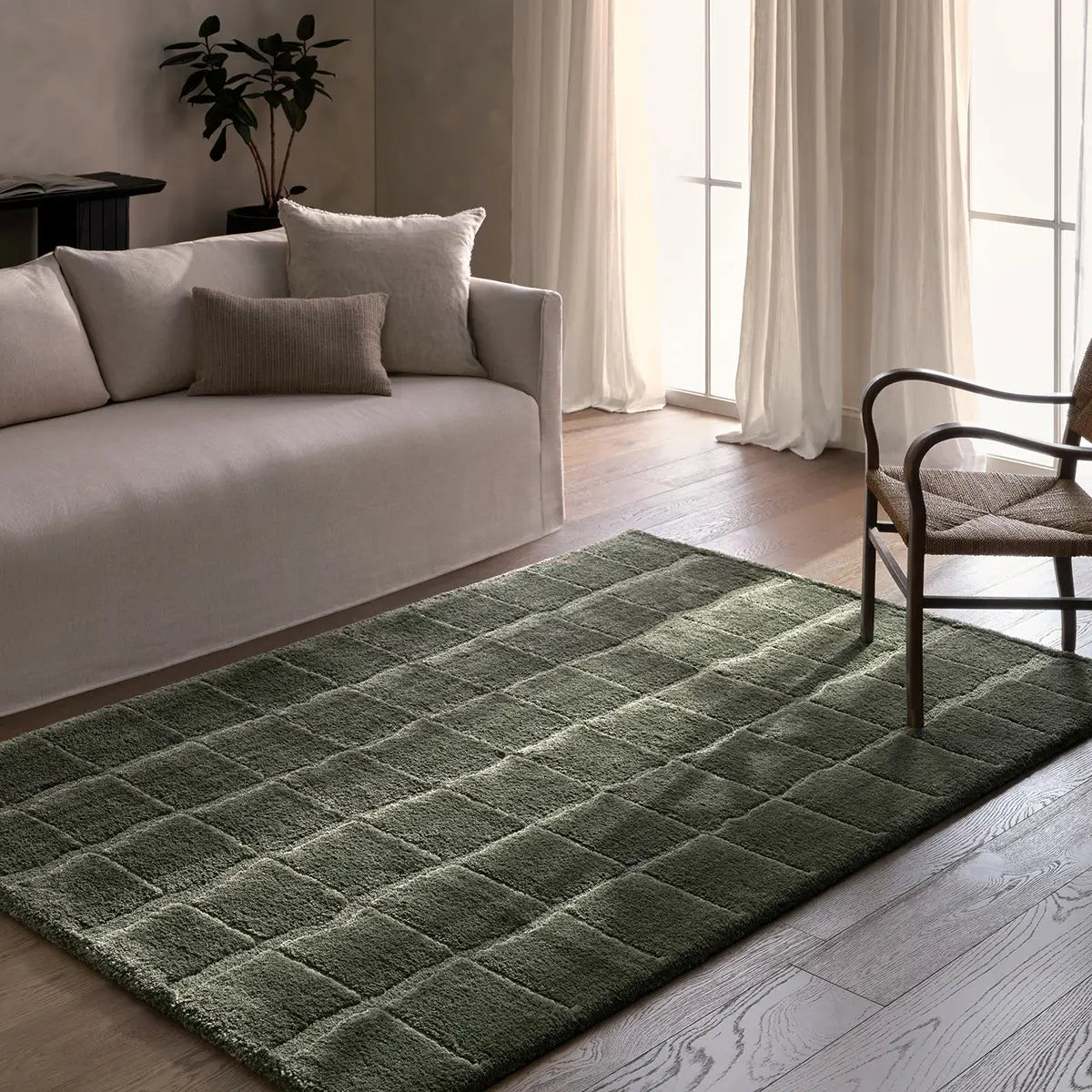 Green checkered rug in a living room with a sofa and chair.