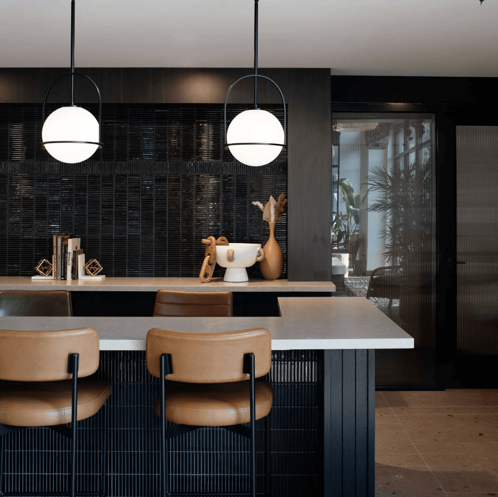Modern kitchen and living room interior design with dark walls, light wood accents, and decorative elements.
