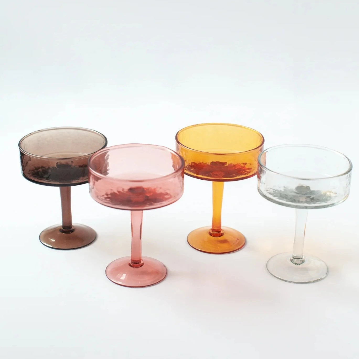 Four colorful glass goblets on a white background