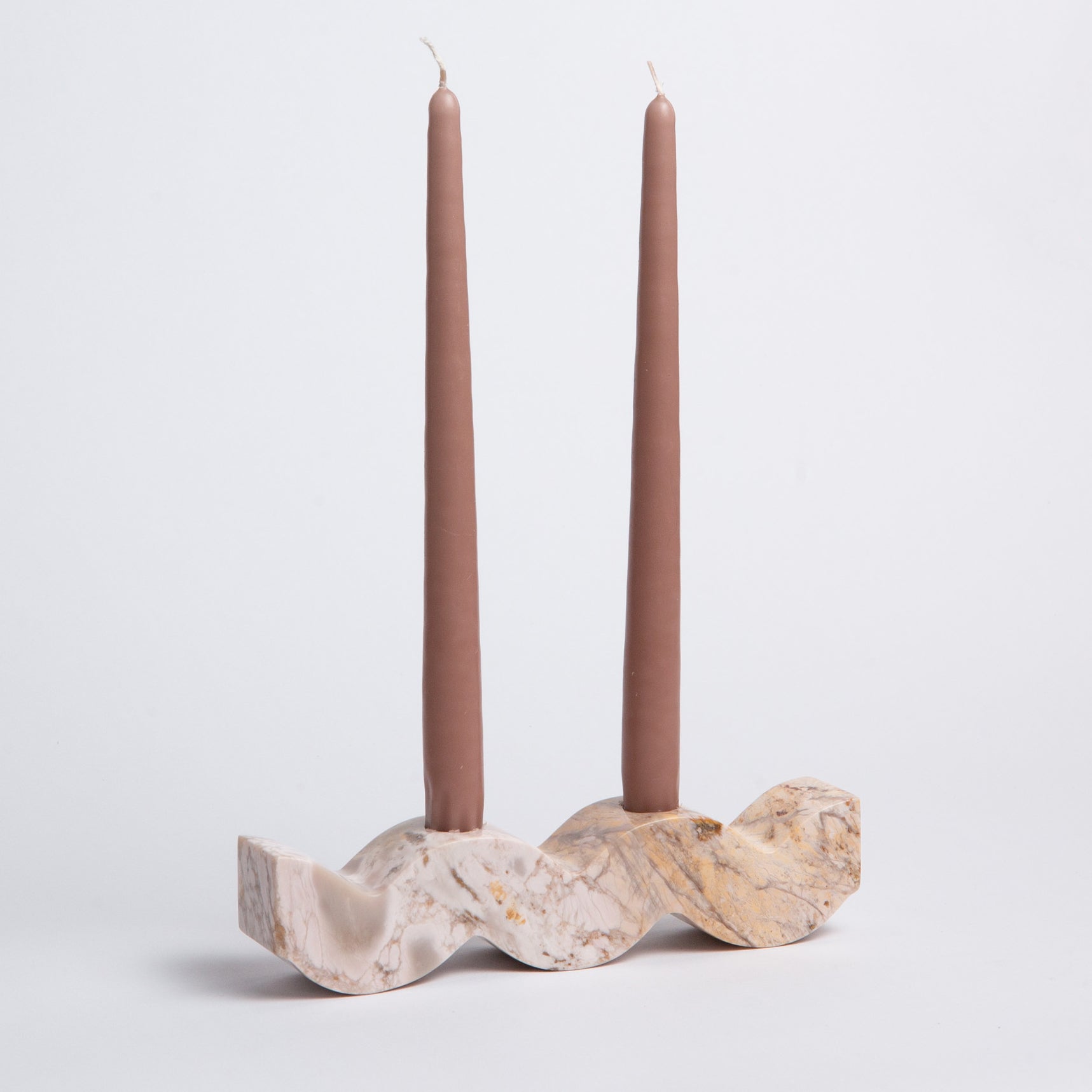 Marble candle holder with two mauve candles on a light gray background