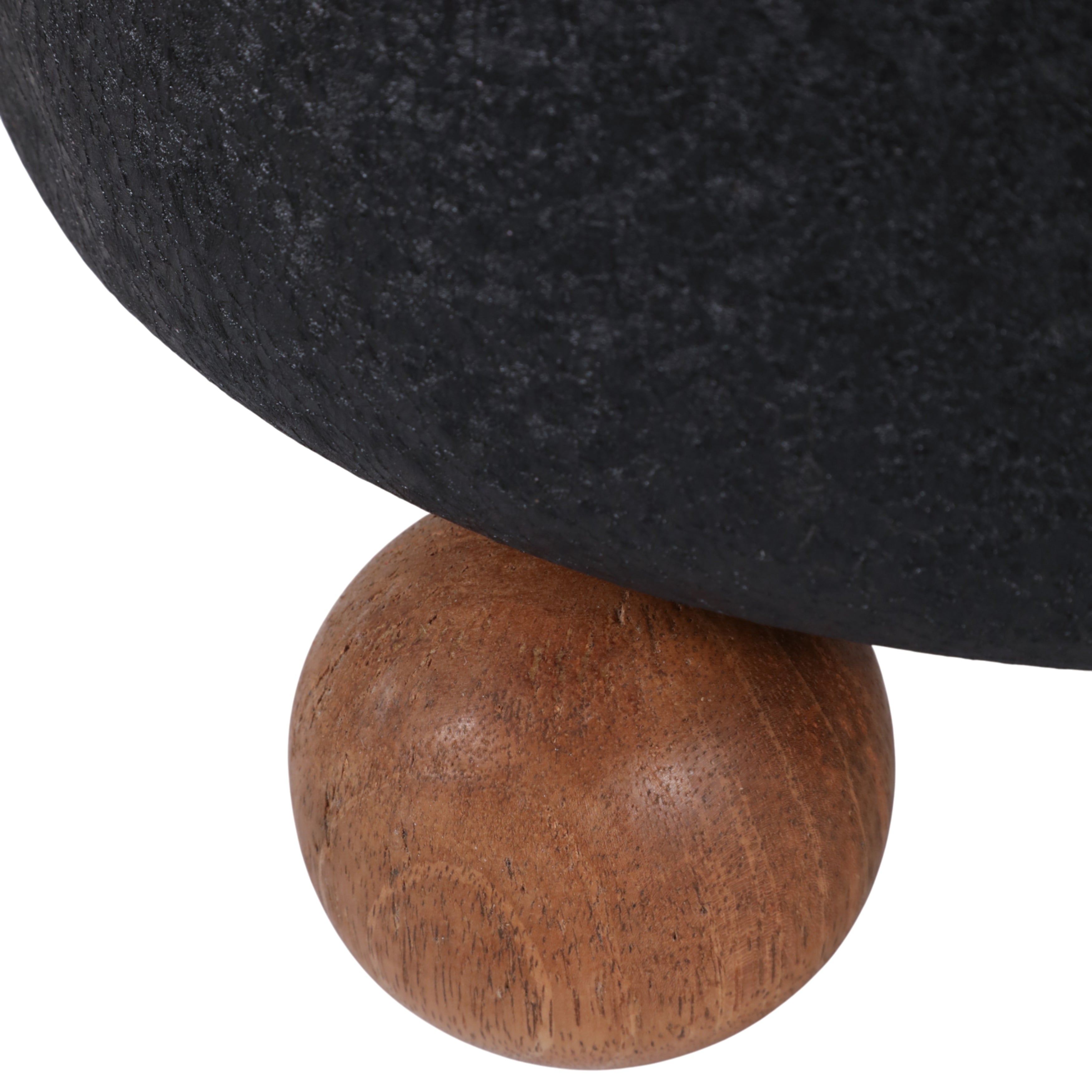 Close-up of a black upholstered chair with a wooden ball foot on a white background