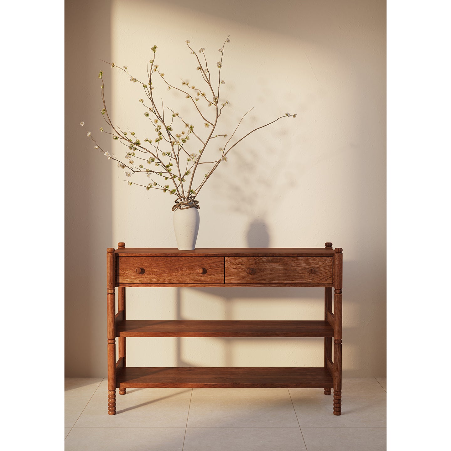 A mid-century modern wooden console table with two drawers and open shelves, styled with a white ceramic vase holding delicate flowering branches, set against a warm beige wall.