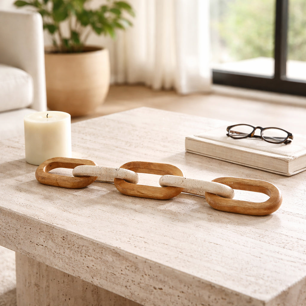Wooden chain on a coffee table with a candle, book, and glasses in a living room setting.