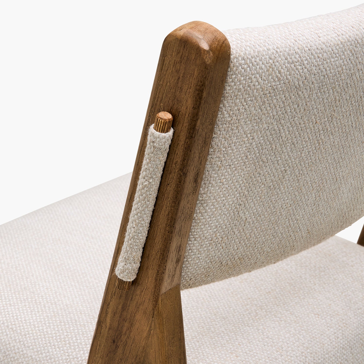 Close-up of a wooden armrest with a fabric cover on a chair.