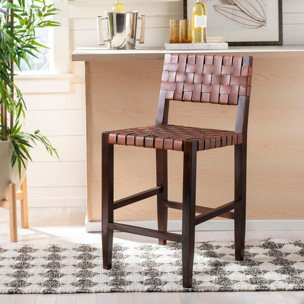 Wooden bar stool with woven seat and backrest in a home setting.