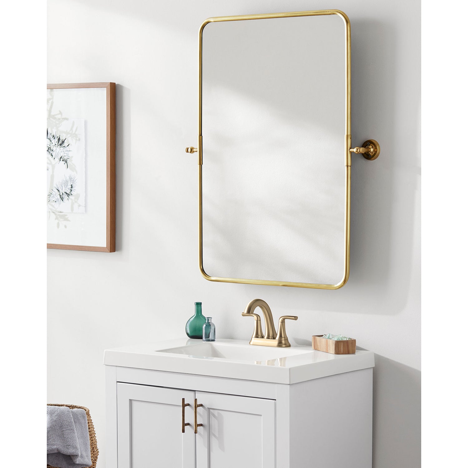 Bathroom vanity with gold-framed mirror and fixtures