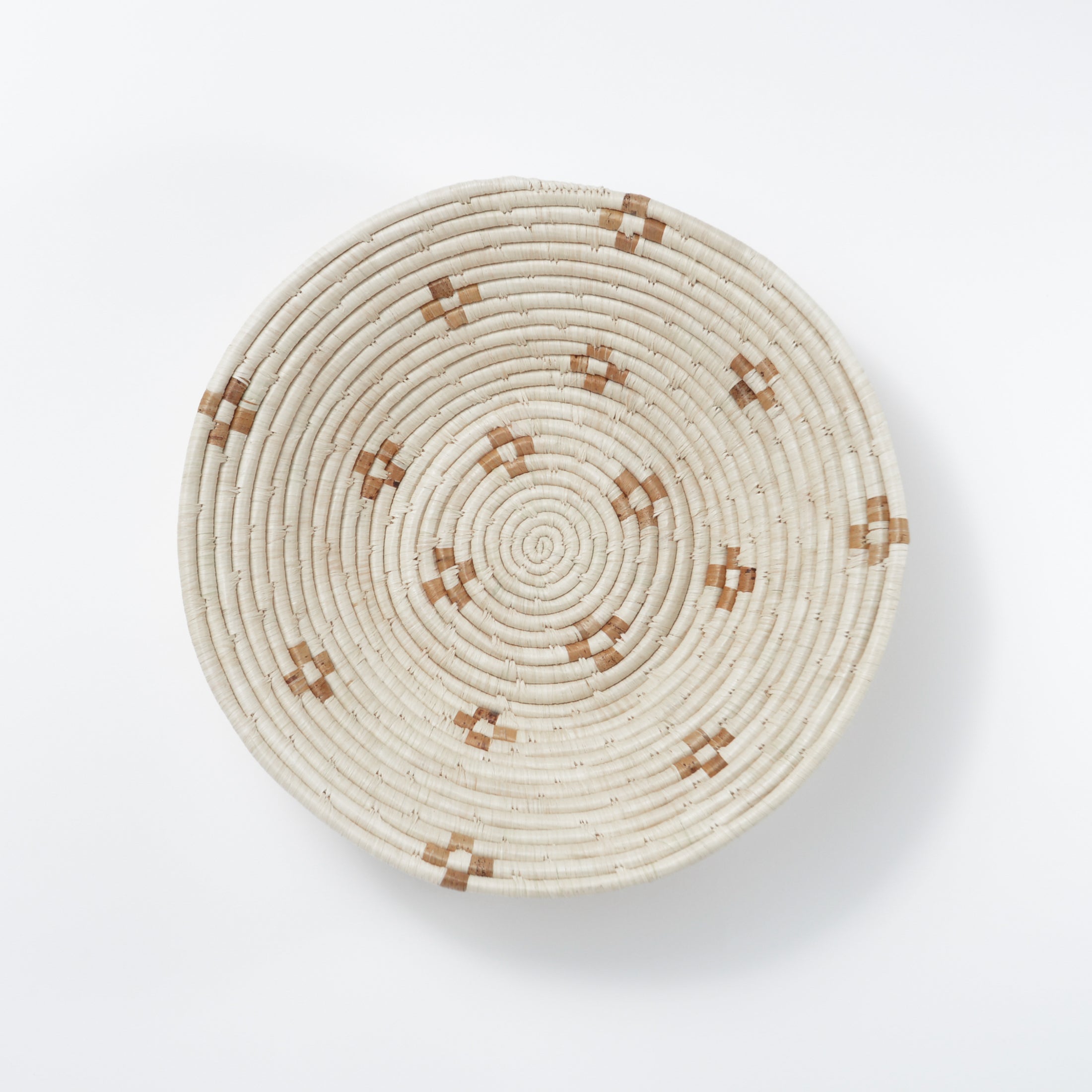Round woven basket with brown patterns on a white background