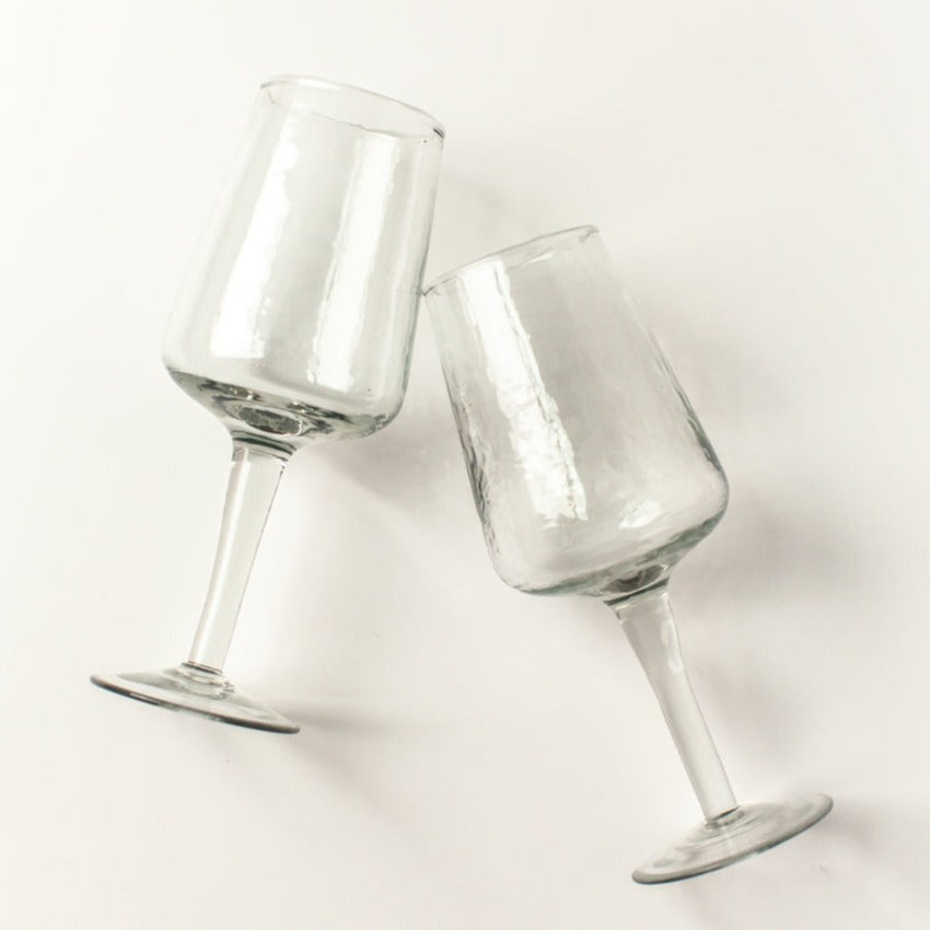Two clear glass wine glasses on a white background