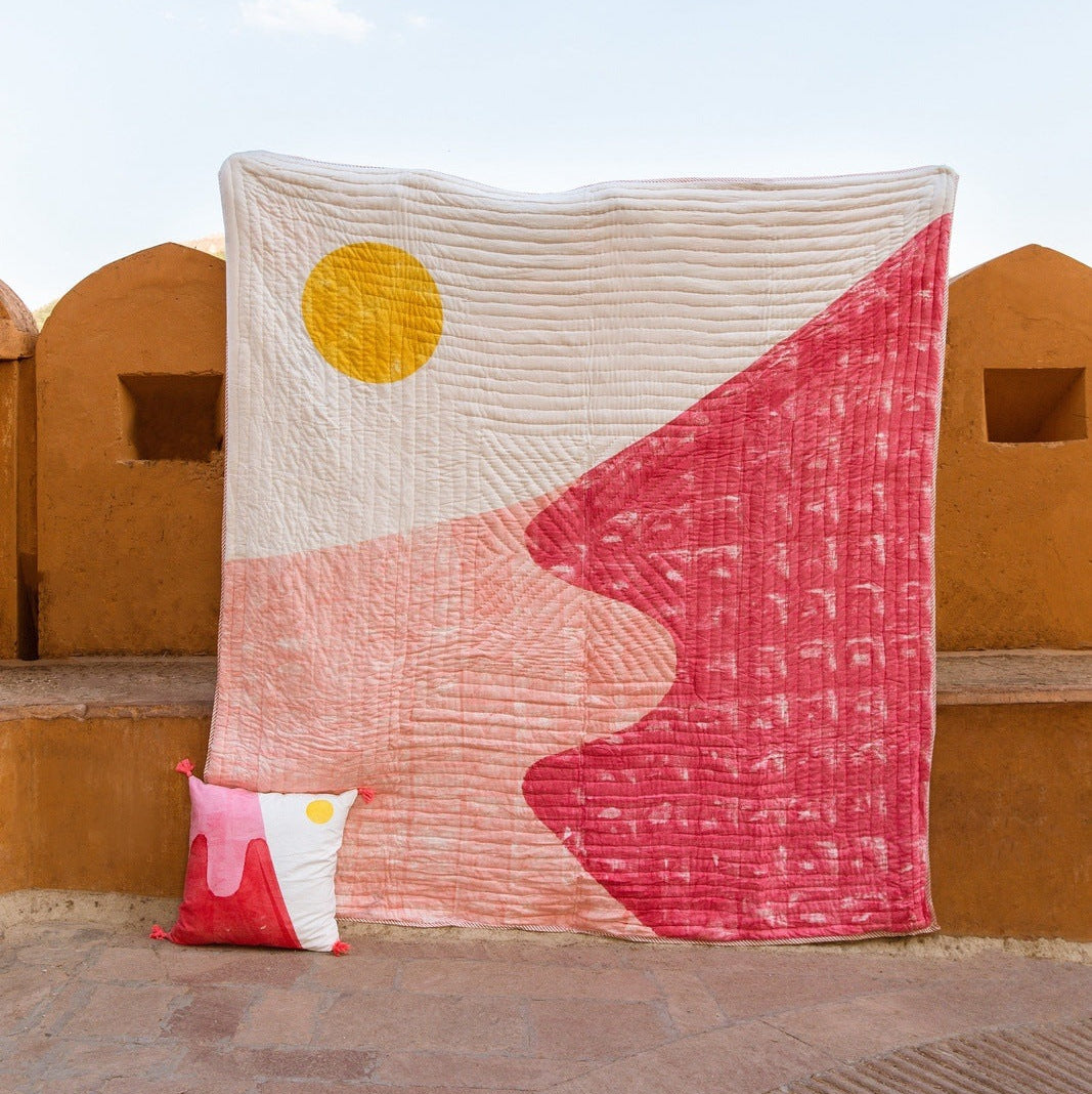 Decorative quilt with geometric pattern on a rooftop with a blue sky background