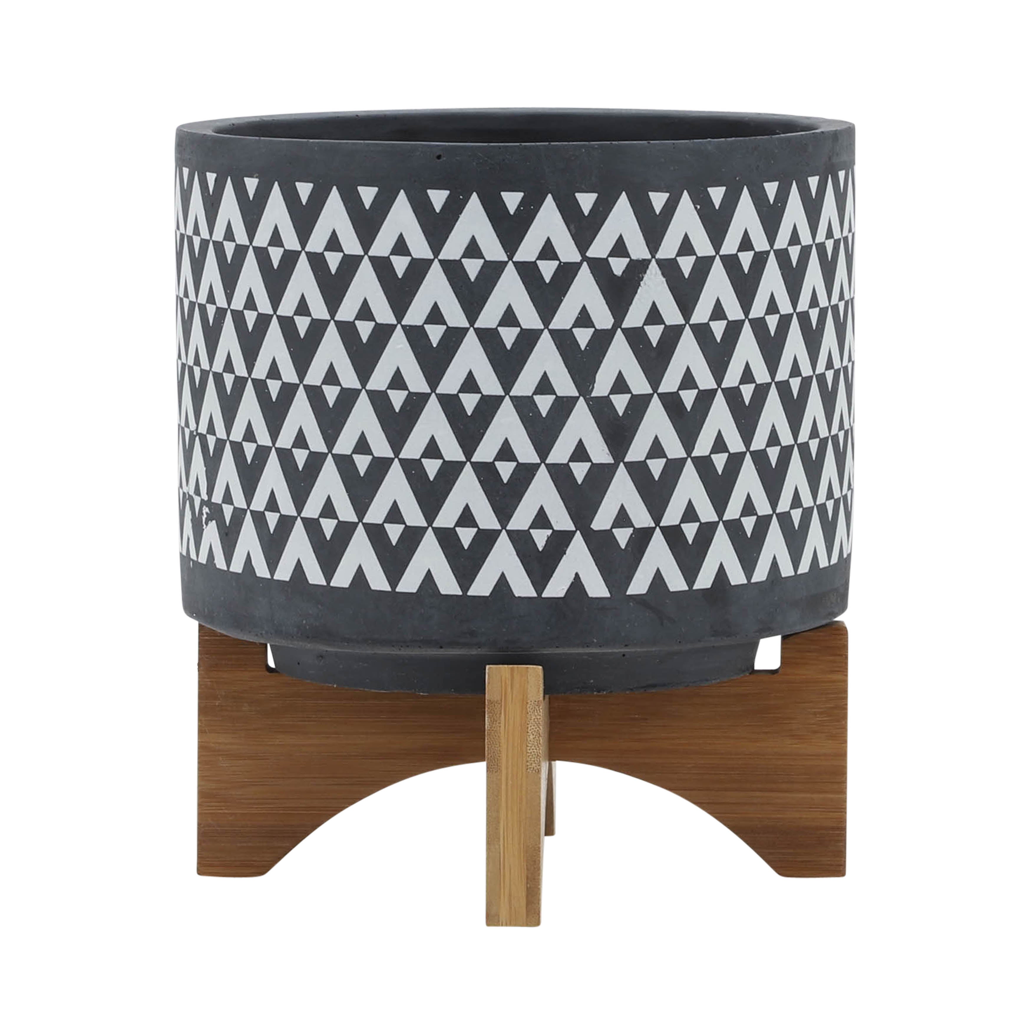 Decorative planter with geometric pattern and wooden stand on a white background