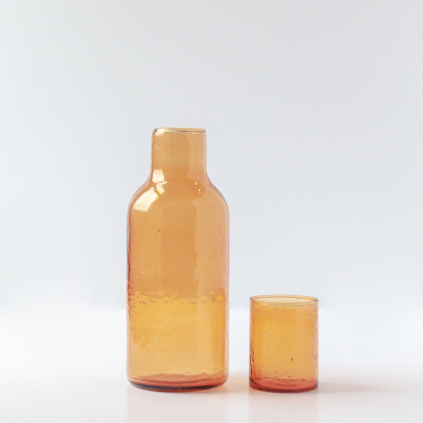 amber-colored glass carafe set on a white background