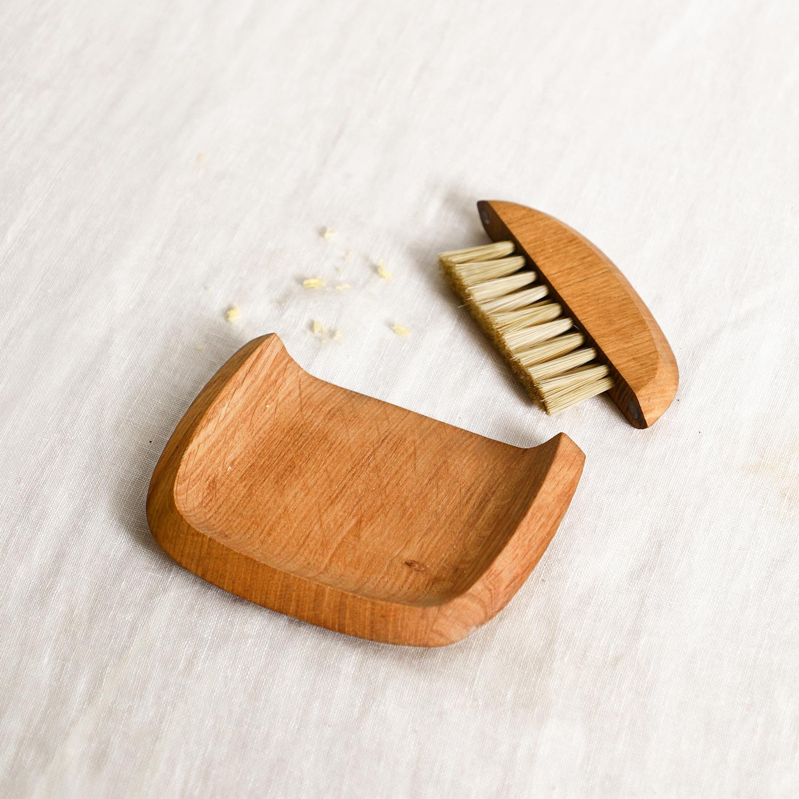 Wooden crumb brush with bristles on a light wooden surface