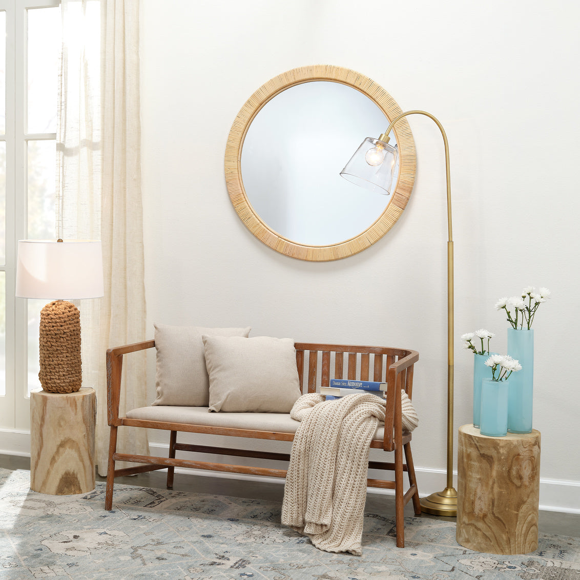 Nautical-themed room with wooden bench, round mirror, and woven rope table lamp