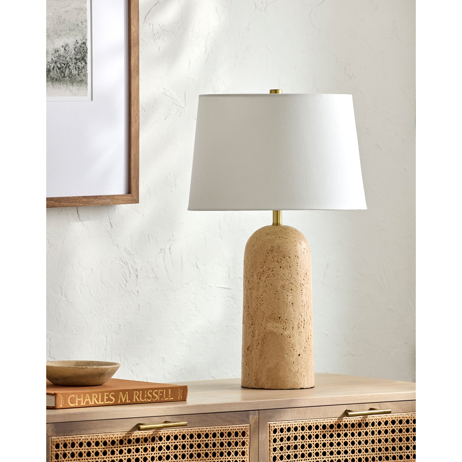 Table lamp with beige base and white shade on a wooden surface.