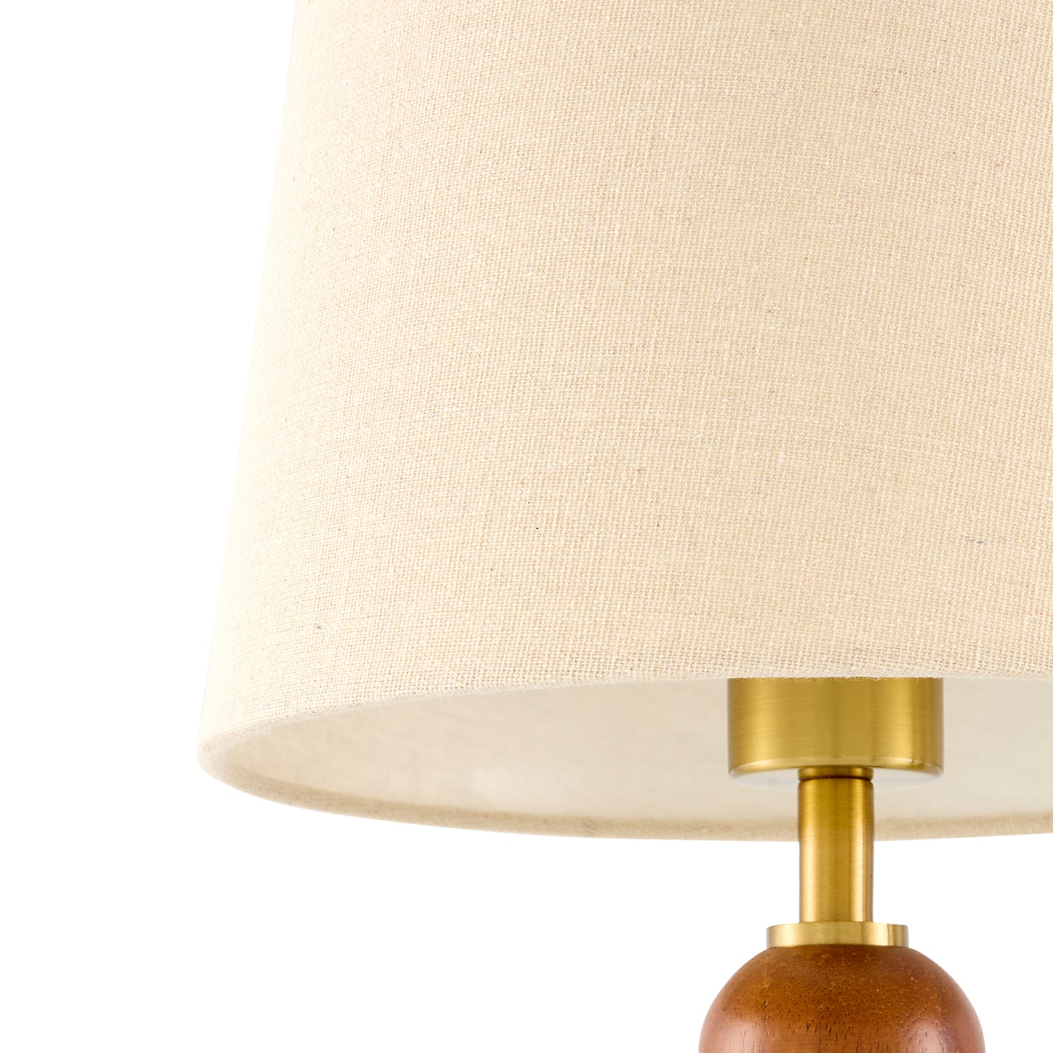 Close-up of a lamp with a beige shade and wooden base on a white background