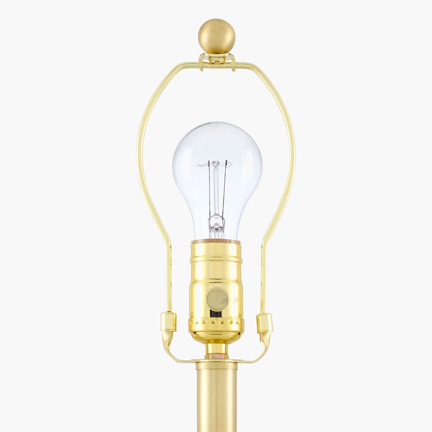 Clear light bulb in a gold holder on a white background