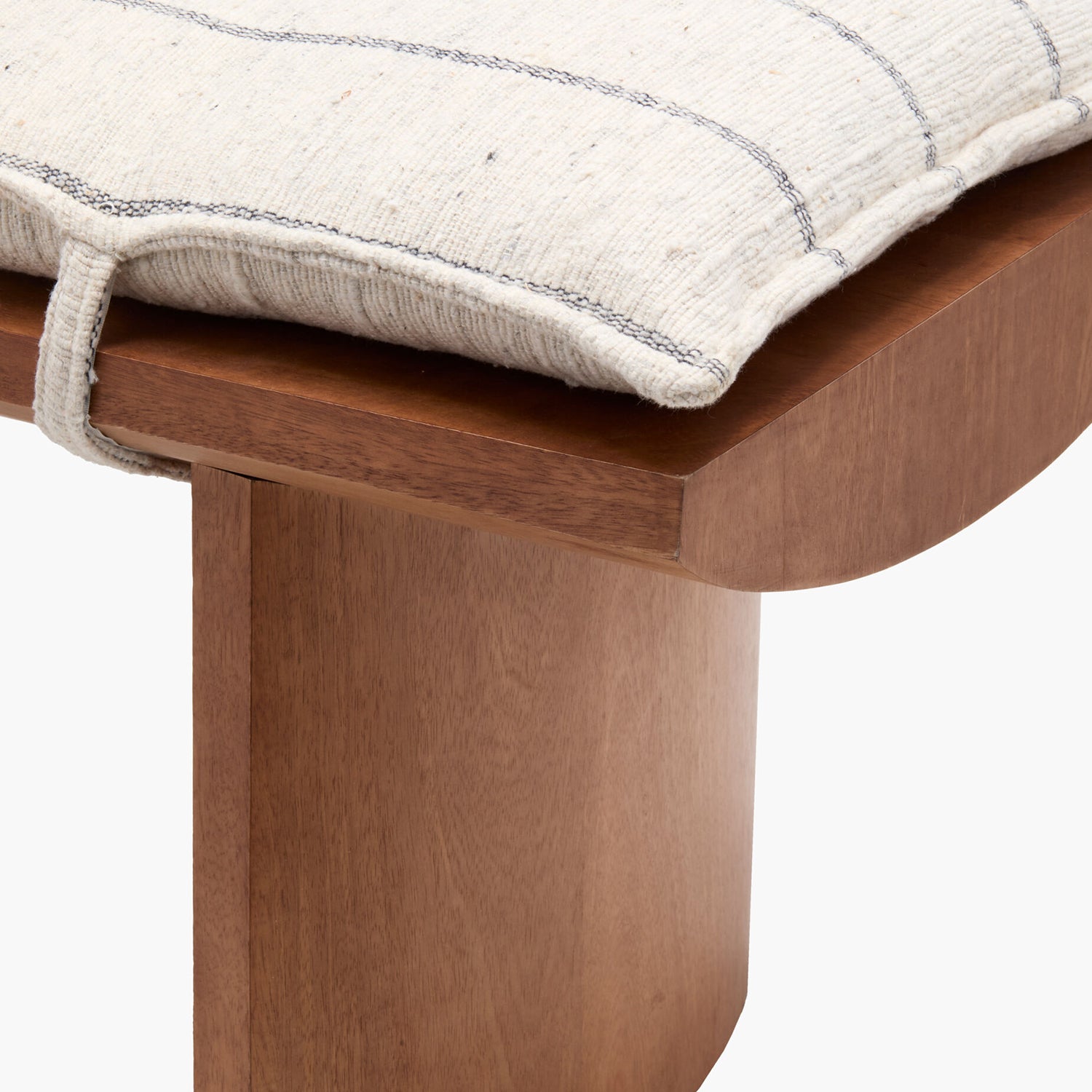 Wooden stool with a textured cushion on a white background