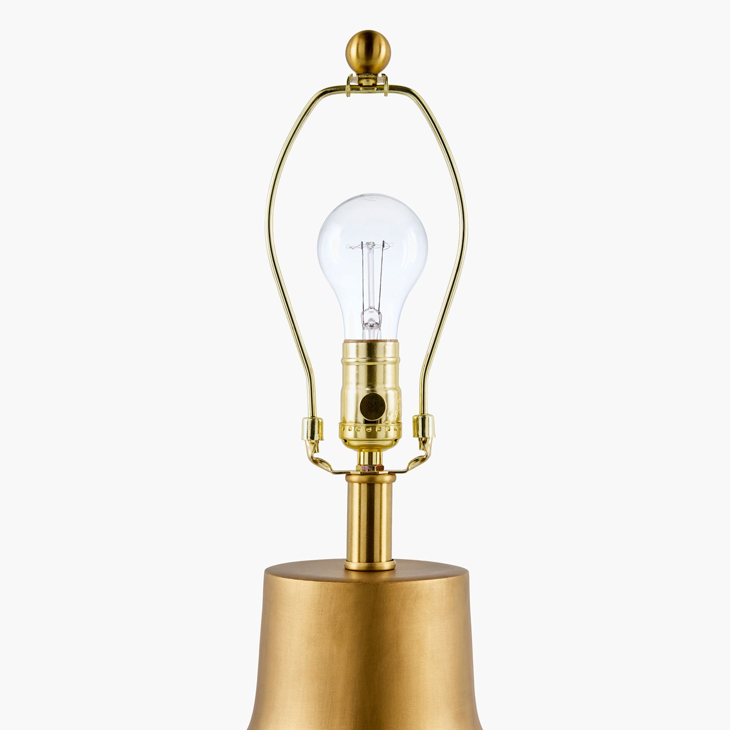 Gold table lamp with clear bulb on a white background