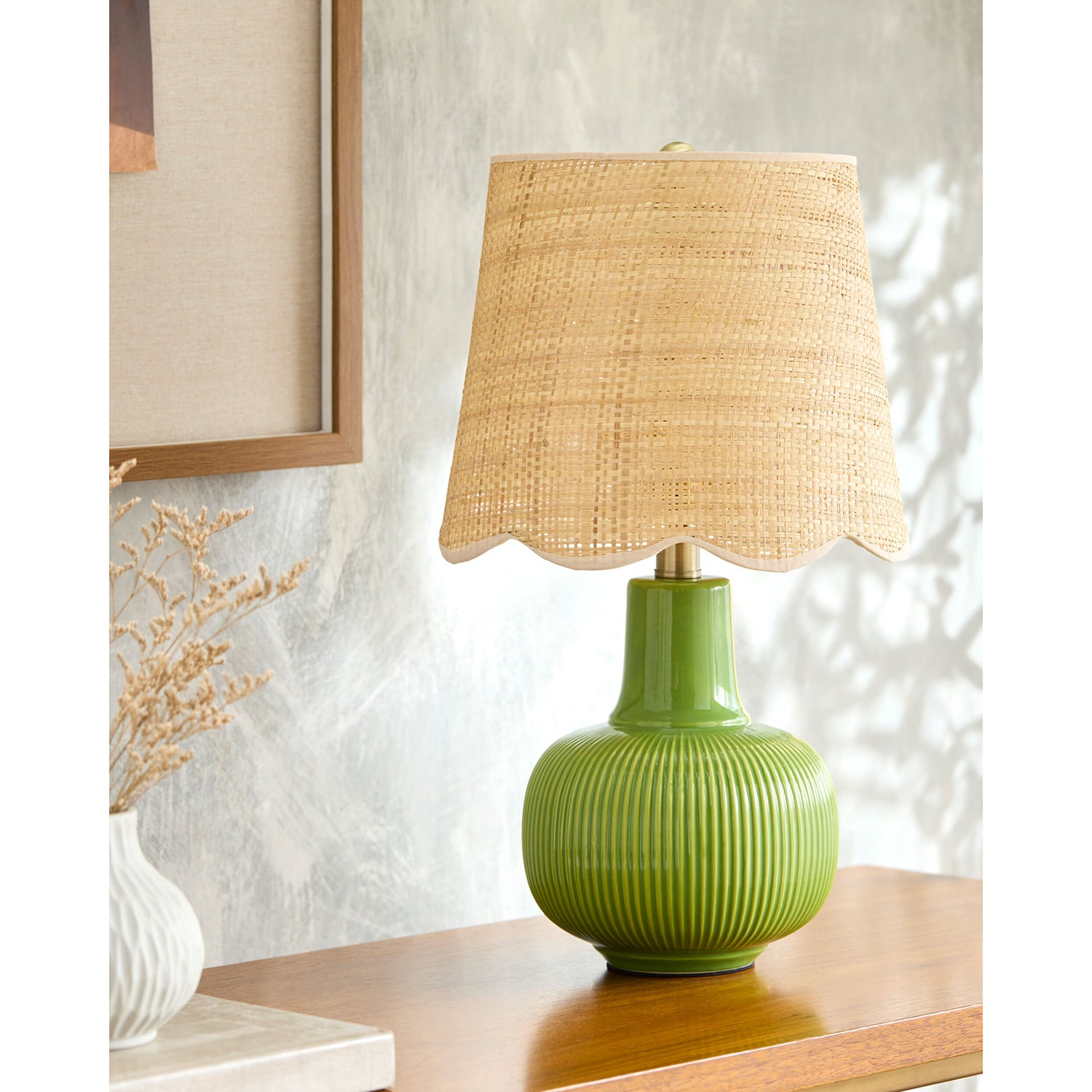 Green lamp with a wicker shade on a wooden surface