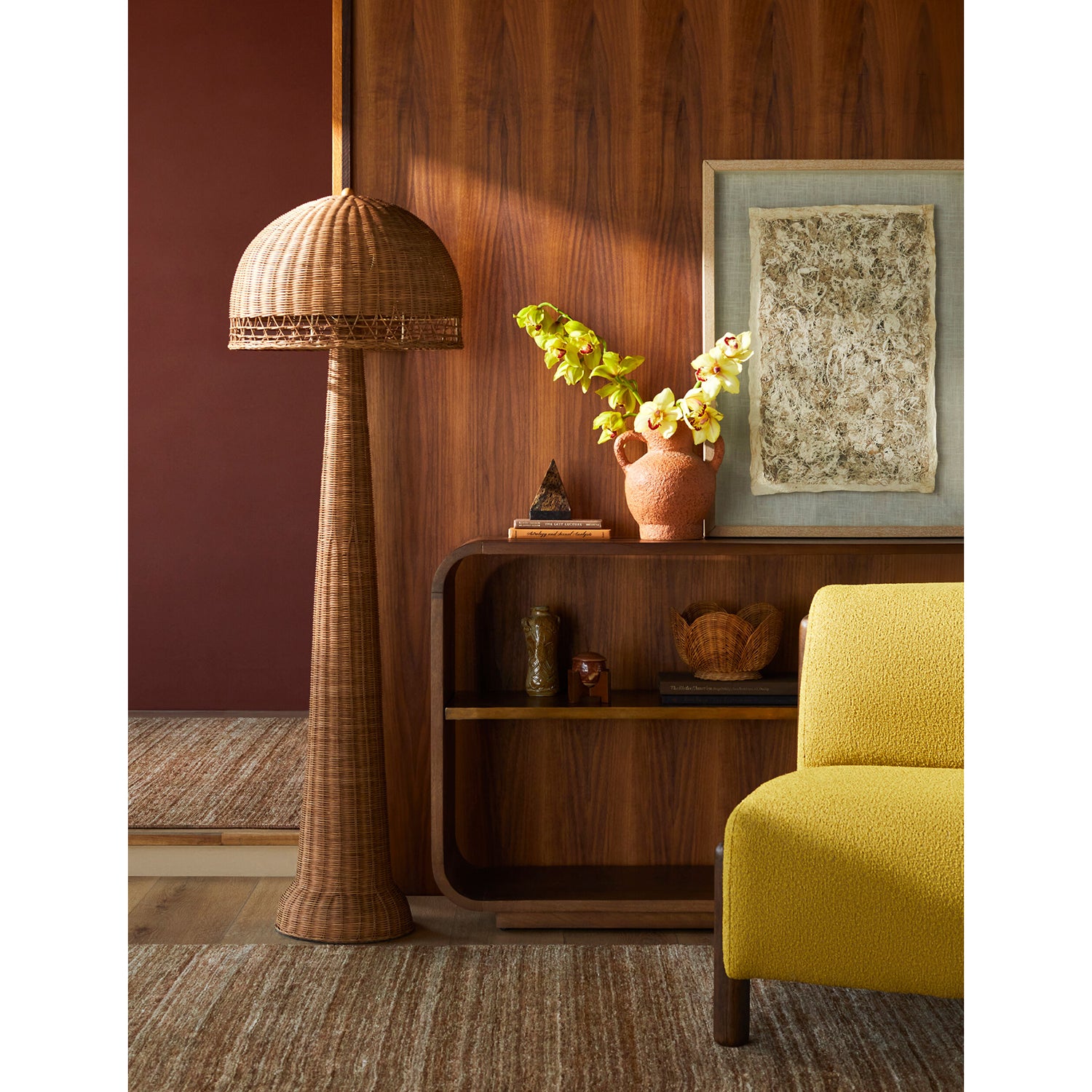 Living room with a tall wicker floor lamp, wooden shelf, and yellow armchair.