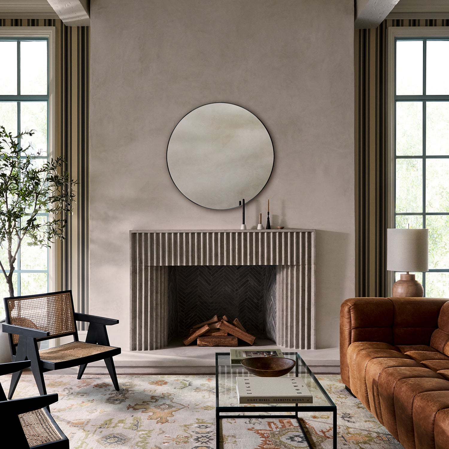 Modern living room with a fireplace, brown sofa, and decorative mirror.